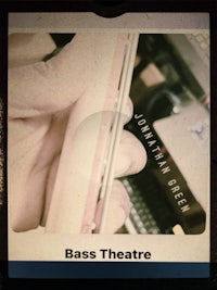 a photo of a person holding a cell phone with the word bass theatre on it